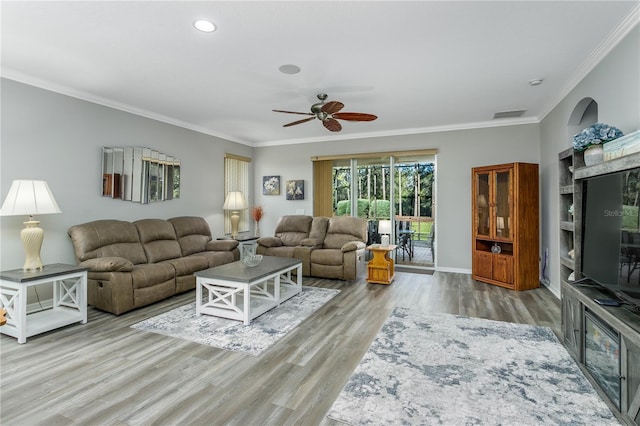 living room with crown molding, ceiling fan, and light hardwood / wood-style flooring