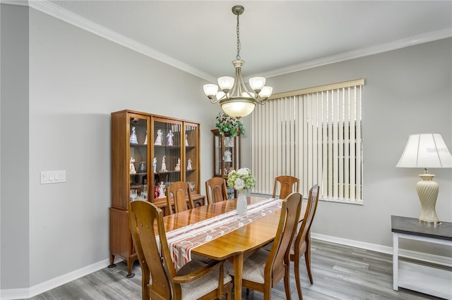 dining room with crown molding, hardwood / wood-style floors, and a notable chandelier