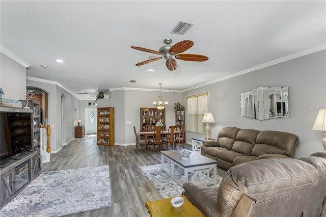 living room featuring ornamental molding, ceiling fan with notable chandelier, and hardwood / wood-style floors