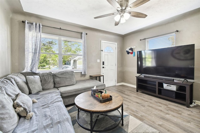 living room featuring light hardwood / wood-style floors, a wealth of natural light, and ceiling fan