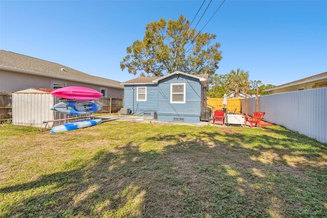 rear view of house with central AC and a yard