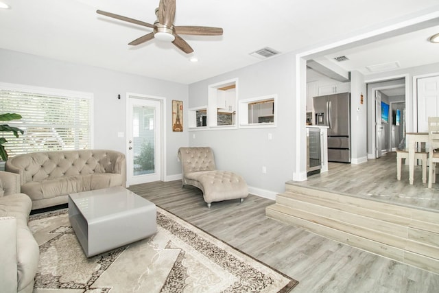 living room featuring wine cooler, ceiling fan, and light hardwood / wood-style floors