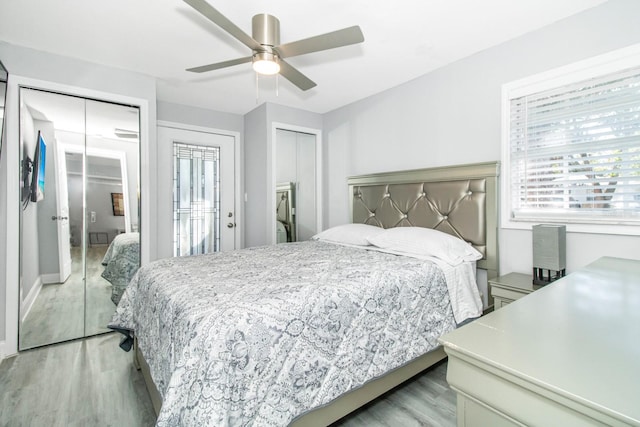 bedroom featuring multiple closets, ceiling fan, and light hardwood / wood-style flooring