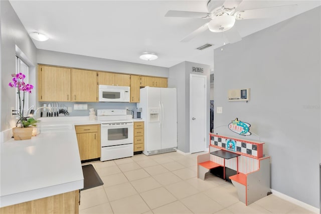 kitchen featuring white appliances, sink, ceiling fan, light tile patterned floors, and light brown cabinetry