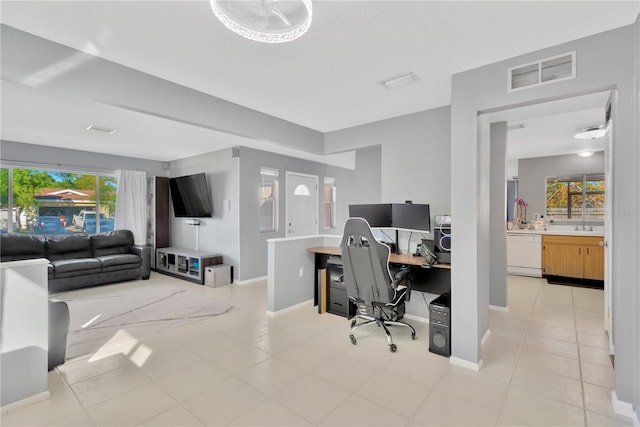 home office with light tile patterned floors and a wealth of natural light