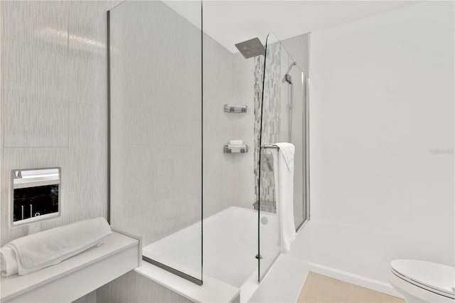 bathroom with tile patterned floors, toilet, and bath / shower combo with glass door