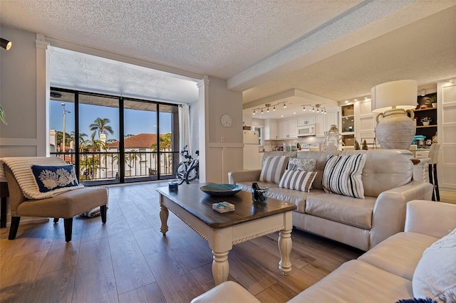 living room featuring a textured ceiling, hardwood / wood-style flooring, and a wall of windows