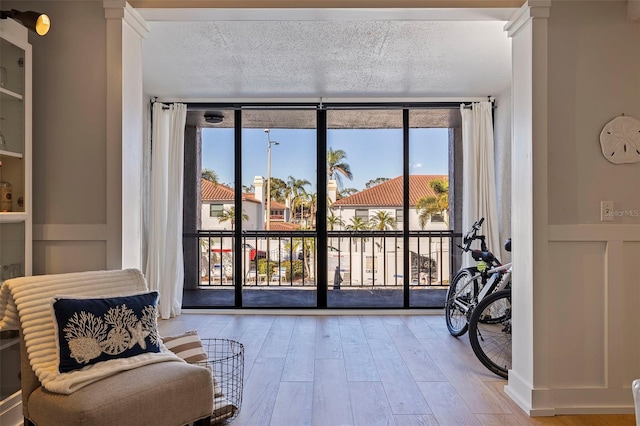 living area featuring hardwood / wood-style floors, a textured ceiling, expansive windows, and plenty of natural light