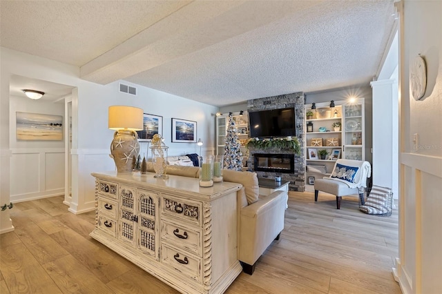 living room with light wood-type flooring and a textured ceiling