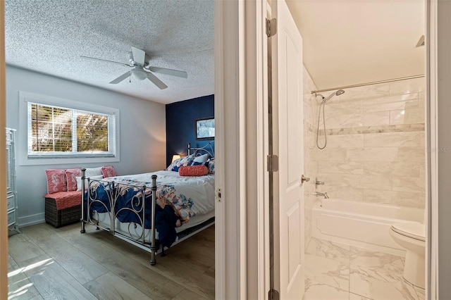 bedroom featuring hardwood / wood-style flooring, ceiling fan, and a textured ceiling