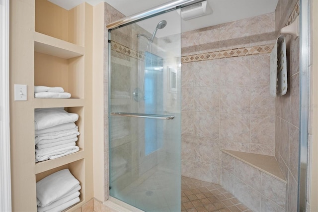 bathroom with built in shelves and an enclosed shower