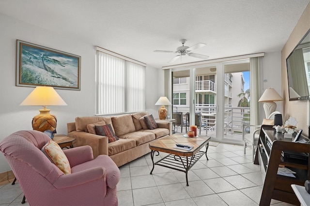 living room featuring light tile patterned flooring, ceiling fan, and a textured ceiling