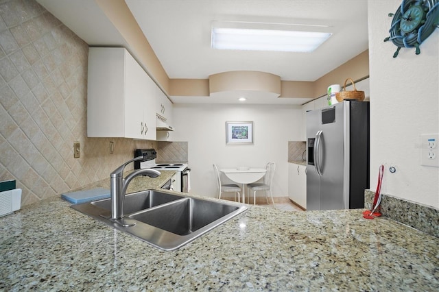 kitchen featuring sink, stainless steel fridge with ice dispenser, range with electric stovetop, decorative backsplash, and white cabinets