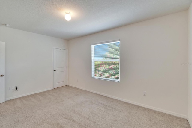 carpeted spare room featuring a textured ceiling