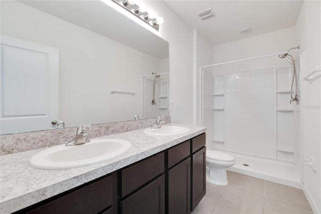 bathroom with tile patterned floors, vanity, toilet, and a shower