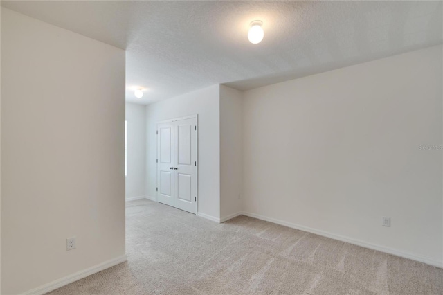 carpeted spare room featuring a textured ceiling