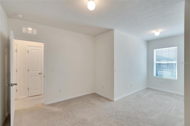 carpeted empty room with a textured ceiling