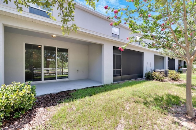 rear view of property with a lawn and a patio