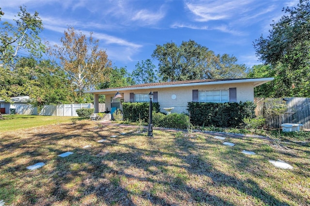 single story home featuring a front lawn