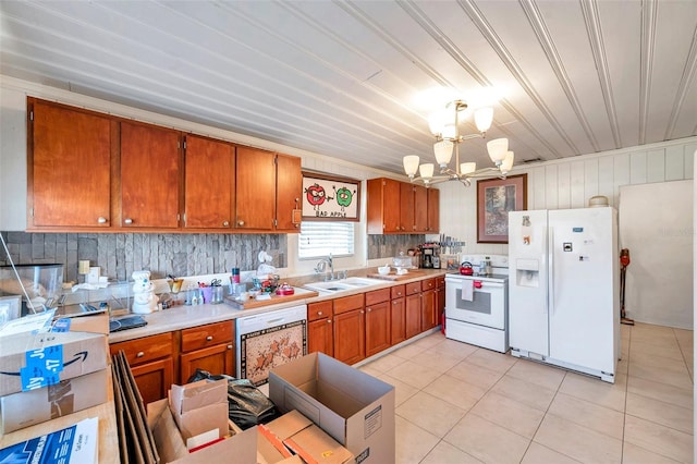 kitchen with white appliances, sink, light tile patterned floors, decorative light fixtures, and a chandelier