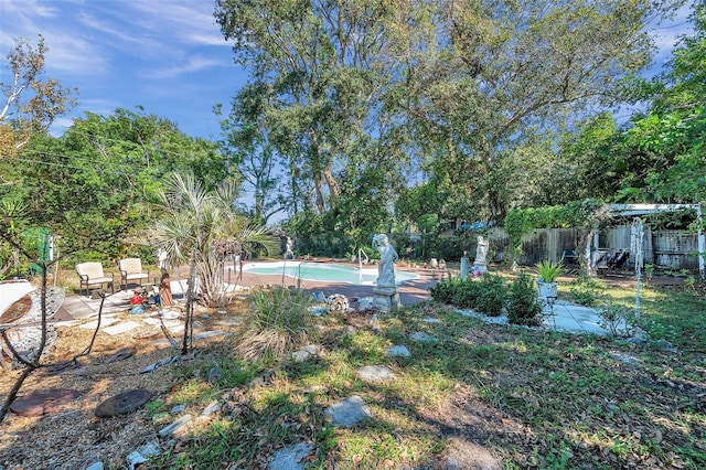 view of yard with a fenced in pool and a patio