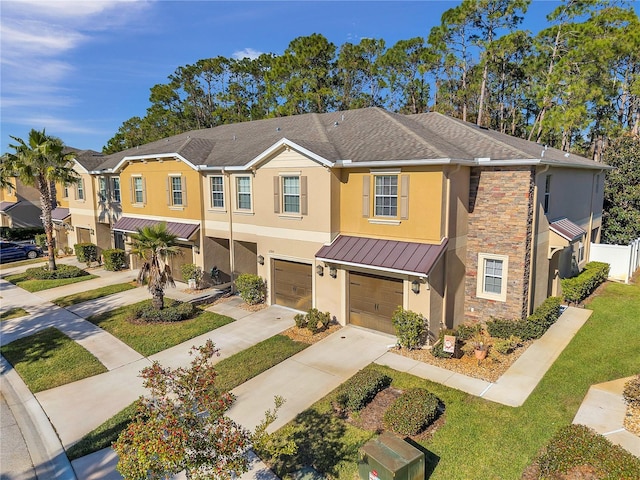 townhome / multi-family property with a front yard and a garage