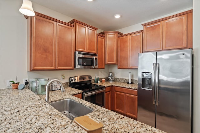 kitchen with light stone counters, sink, and appliances with stainless steel finishes