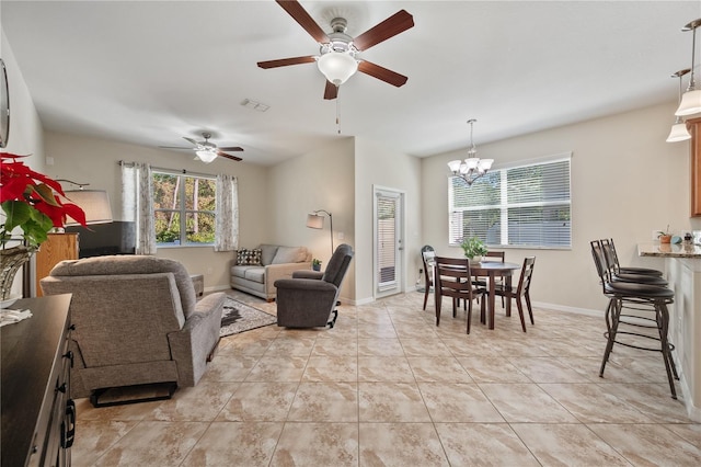 tiled living room with ceiling fan with notable chandelier