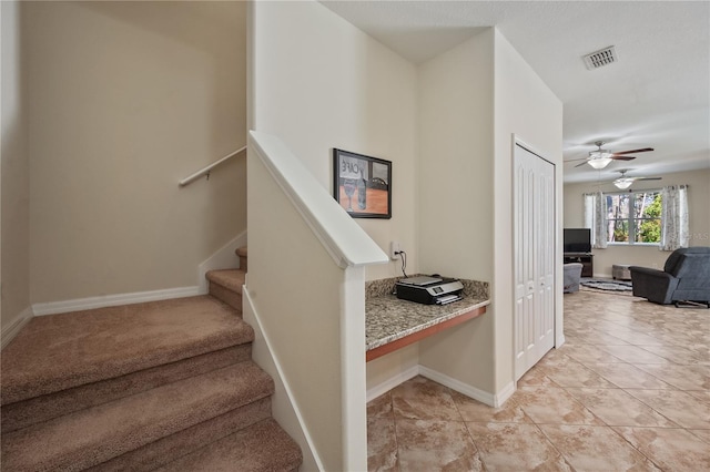 stairway featuring tile patterned floors and ceiling fan