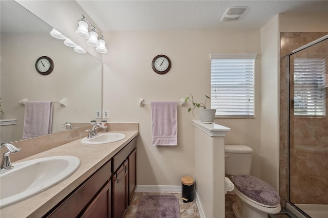 bathroom with tile patterned floors, vanity, toilet, and a shower with door