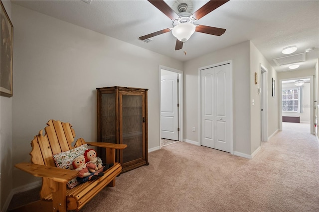 living area featuring light colored carpet and ceiling fan