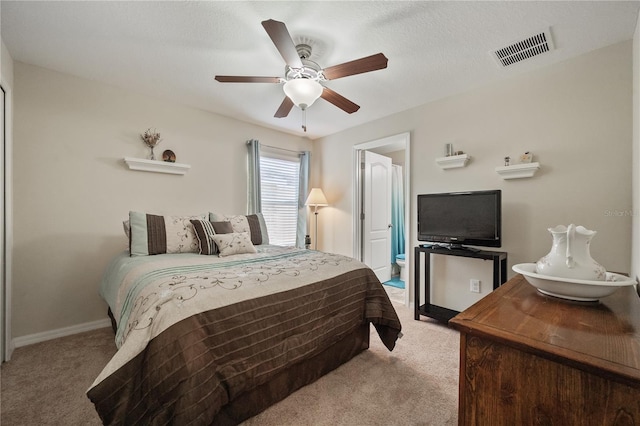 bedroom with ceiling fan, light carpet, and a textured ceiling