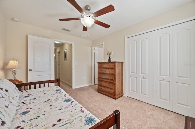 bedroom with a closet, ceiling fan, and light colored carpet