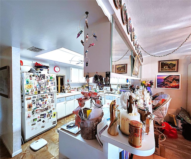 kitchen featuring white cabinetry, light hardwood / wood-style flooring, and white refrigerator