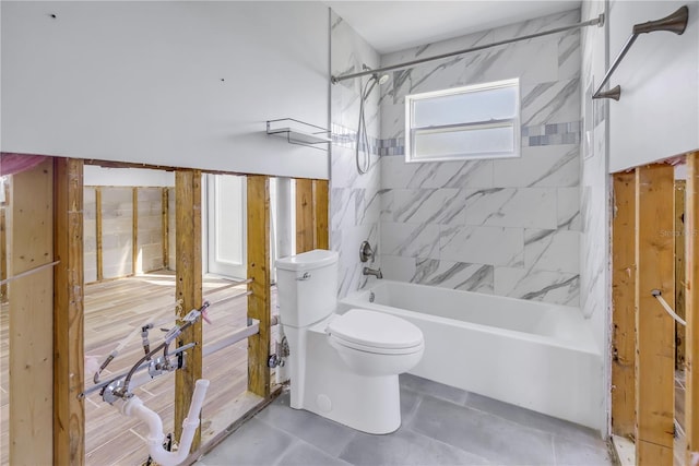 bathroom with tiled shower / bath combo and toilet