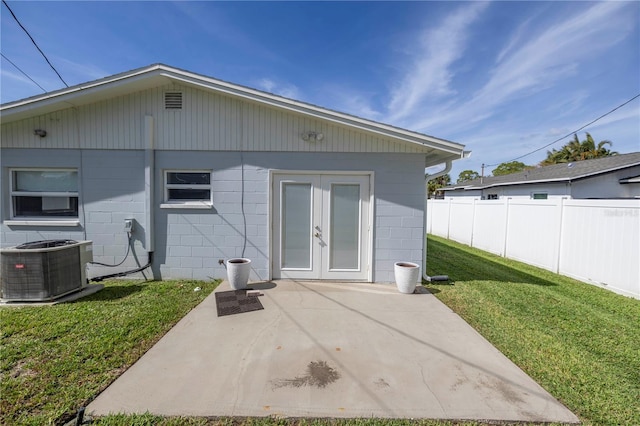 back of property featuring french doors, a patio, a lawn, and central air condition unit