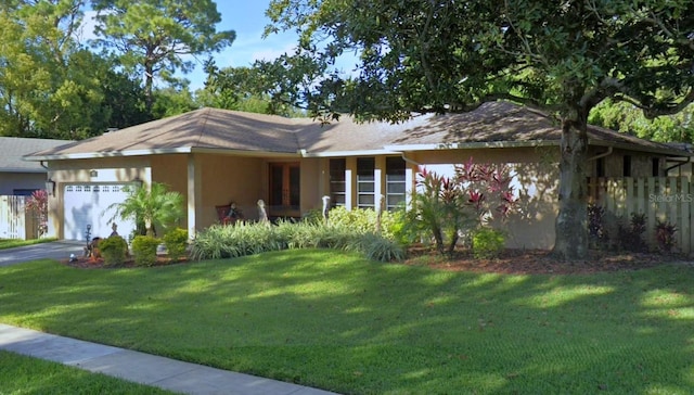 ranch-style home featuring a garage and a front lawn