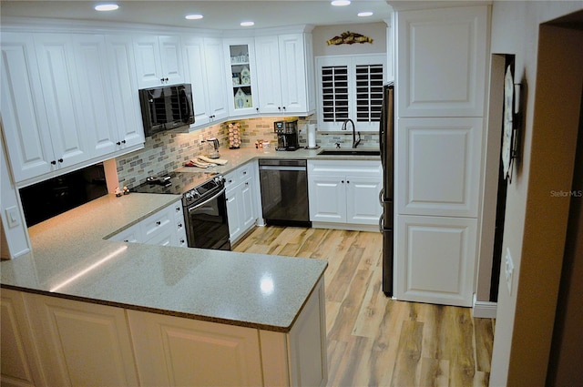 kitchen featuring white cabinetry, sink, stainless steel appliances, light hardwood / wood-style flooring, and kitchen peninsula