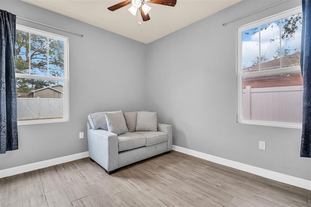 sitting room with ceiling fan and light wood-type flooring