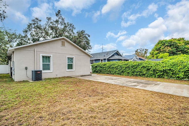 view of side of home with central air condition unit and a lawn