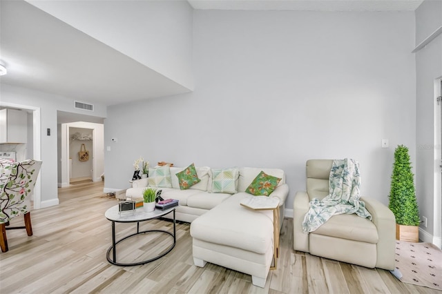 living room with baseboards, visible vents, and light wood-style floors