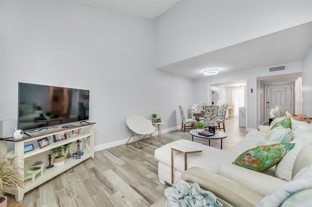 living room featuring wood finished floors, visible vents, and baseboards