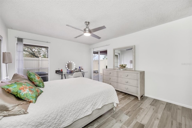 bedroom featuring a textured ceiling, multiple windows, and light wood-type flooring