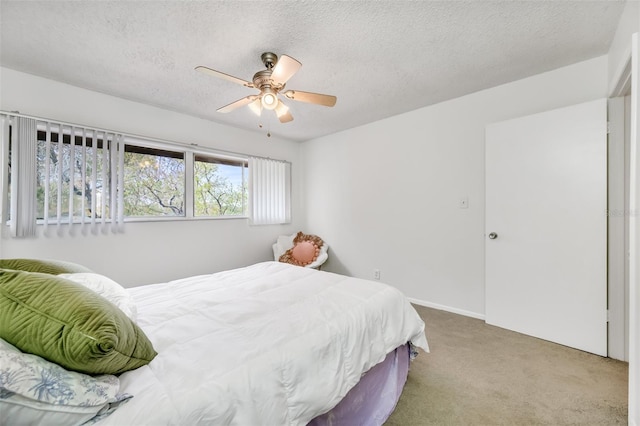 carpeted bedroom with a ceiling fan and a textured ceiling