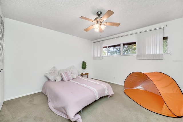 bedroom featuring carpet, baseboards, ceiling fan, and a textured ceiling