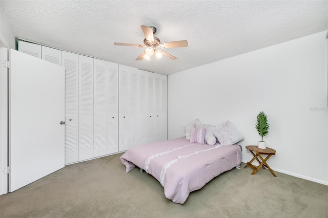 carpeted bedroom with a textured ceiling and a ceiling fan