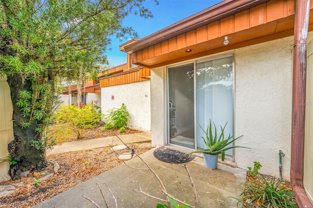 doorway to property featuring a patio and stucco siding