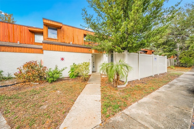 view of front of house with fence and stucco siding