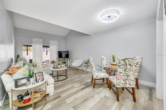 interior space with vaulted ceiling, wood finished floors, and baseboards