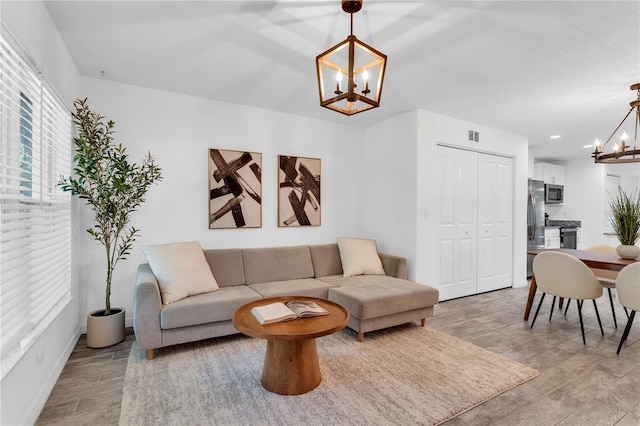 living room with light hardwood / wood-style floors and a chandelier